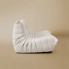 Side view of the TOGO Three Seater Lounger in a light beige studio background