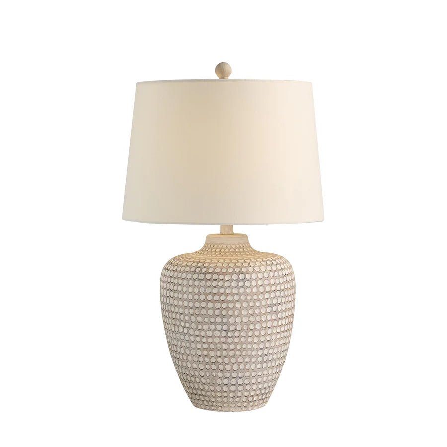 Table lamp with textured resin base and linen lampshade on a white background