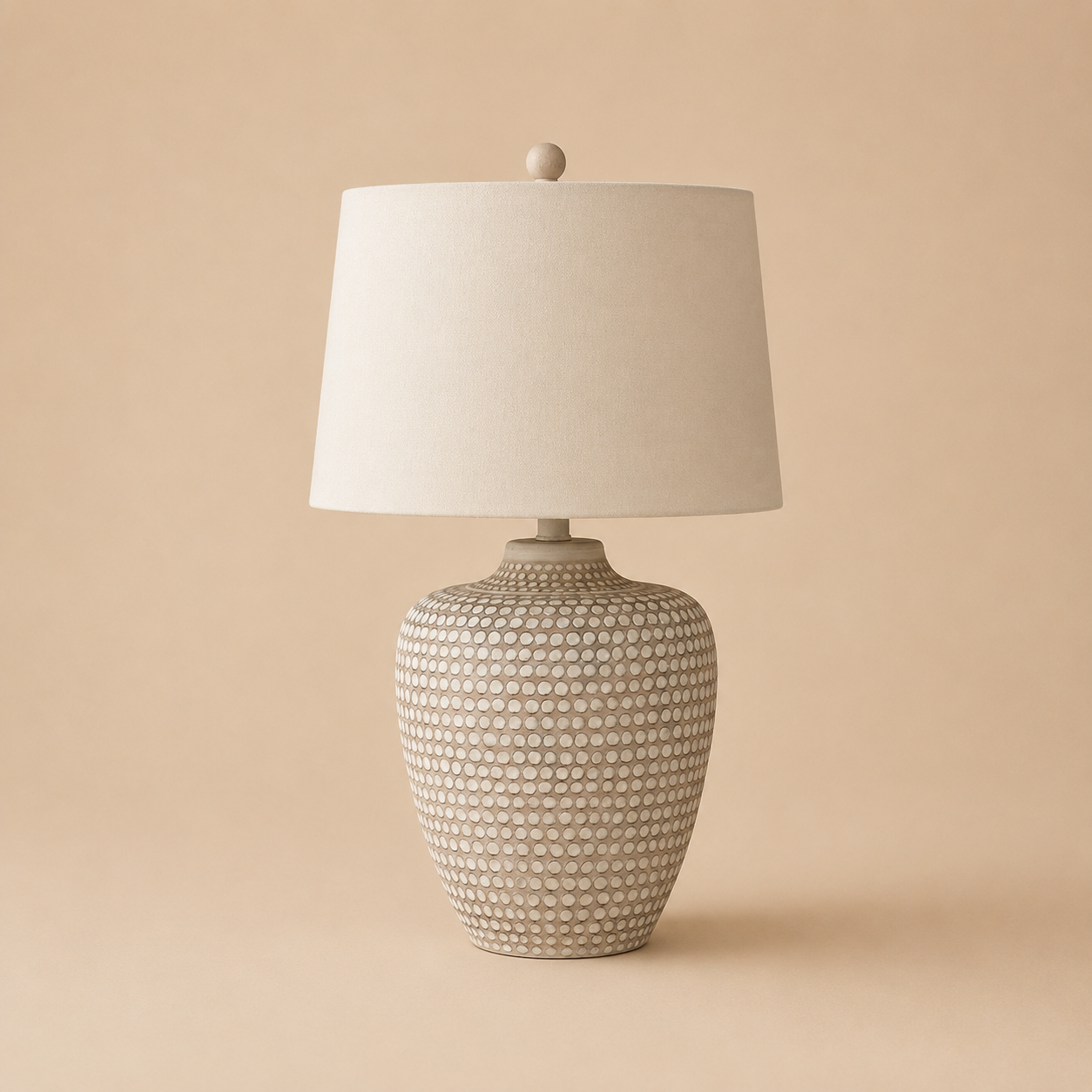 Table lamp with textured base and white shade on a beige background