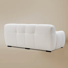 Back angle view of the Gummy loveseat variant, highlighting the plush vertical tufting, boucle fabric, and low-profile silhouette.
