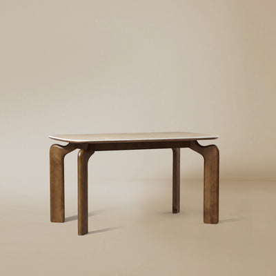 Angle view of Valencia dining table with sintered stone top and curved solid wood legs on beige studio background