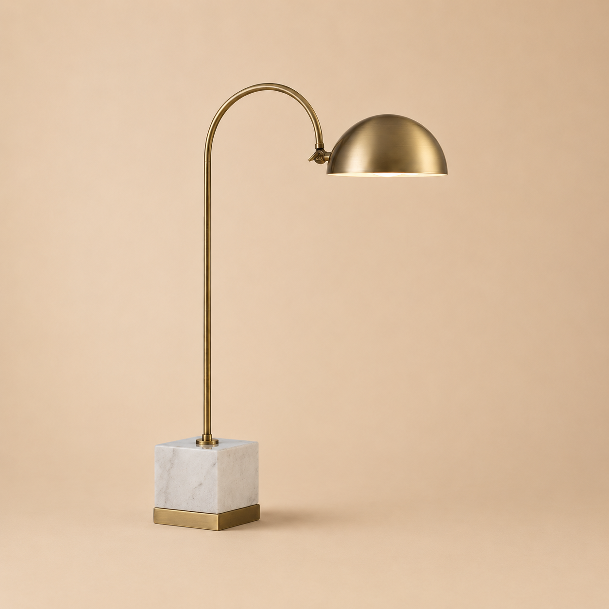 Gold table lamp with marble base on a beige background