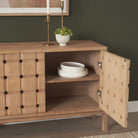 Lifestyle view of the Varelle Carved Mango Wood Sideboard with one door open, showing interior shelf storage for dinnerware.