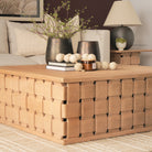 Angled lifestyle view of the Varelle Carved Mango Wood Square Coffee Table styled with books, vases and decorative accents.