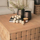 Lifestyle detail of the Varelle Square Coffee Table showing the solid mango wood top styled with books, vases and a candle.