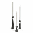Varen set of three antique black hand-hammered iron taper candle holders on a white background.