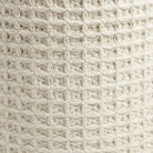 Close-up of a textured beige fabric with a grid pattern