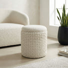 Textured ottoman in a living room setting with a chair and plant.
