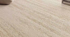 [Velune Ivory Rug] Close-up of the rug in a room setting, showing the warm ivory pile and subtle tonal texture.