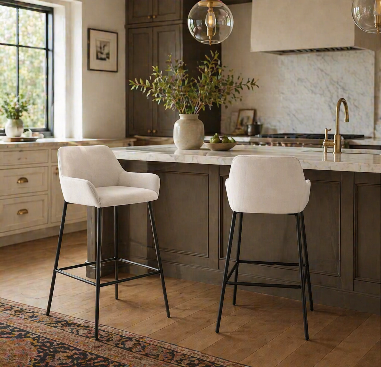 Two white bar stools in a modern kitchen with marble countertops and wooden flooring.