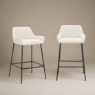 Two white bar stools with black legs on a beige background
