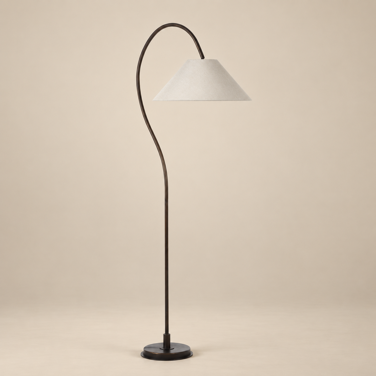 Vienne arc floor lamp featuring a dark antique bronze curved iron frame and oatmeal linen tapered shade on a beige studio background.