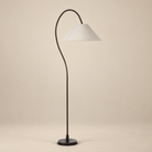 Vienne arc floor lamp featuring a dark antique bronze curved iron frame and oatmeal linen tapered shade on a beige studio background.