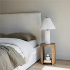 The Vivienne French-seamed bed styled in a neutral bedroom with olive green linen bedding and a fluted side table
