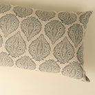 Decorative pillow with black leaf pattern on beige background