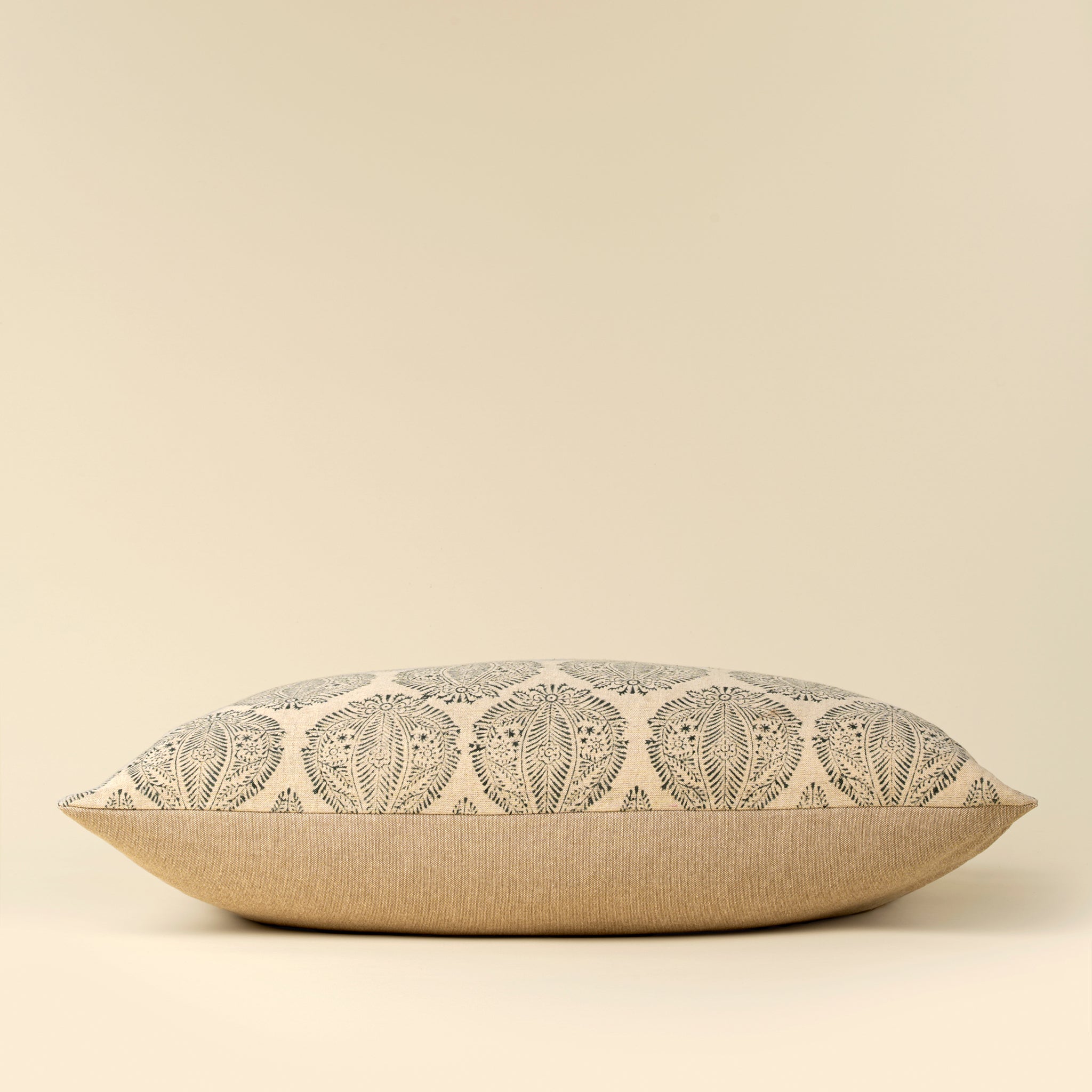 Decorative pillow with leaf pattern on a beige background