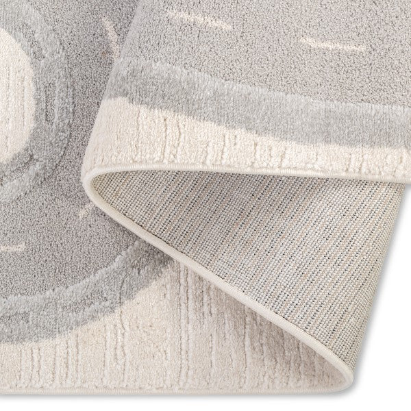 Folded corner view of the Zoomie Lane Kids Rug showing the racetrack design, soft pile and backing.
